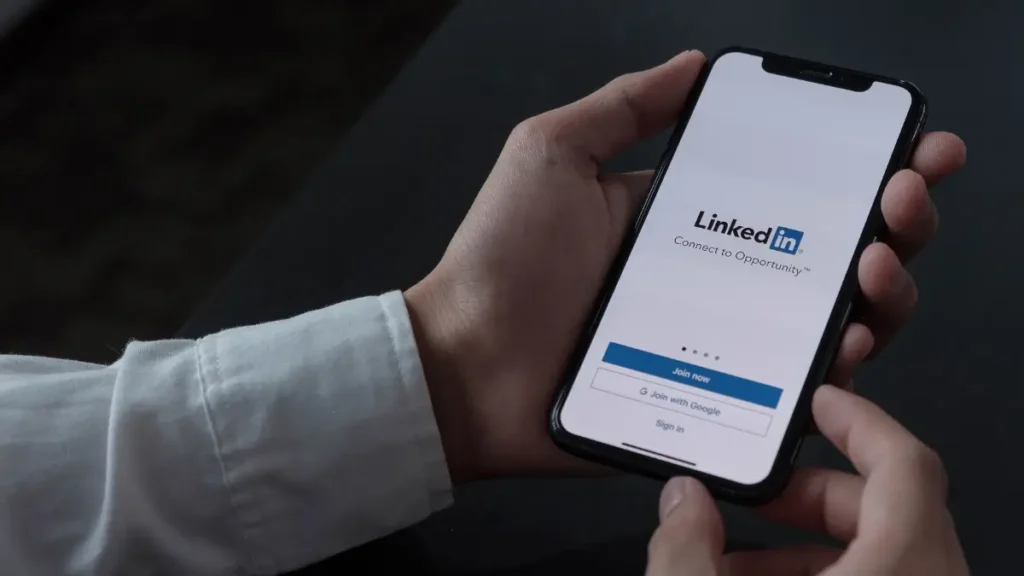 Άνδρας κάνει εγγραφή σε εταιρική σελίδα LinkedIn από κινητό