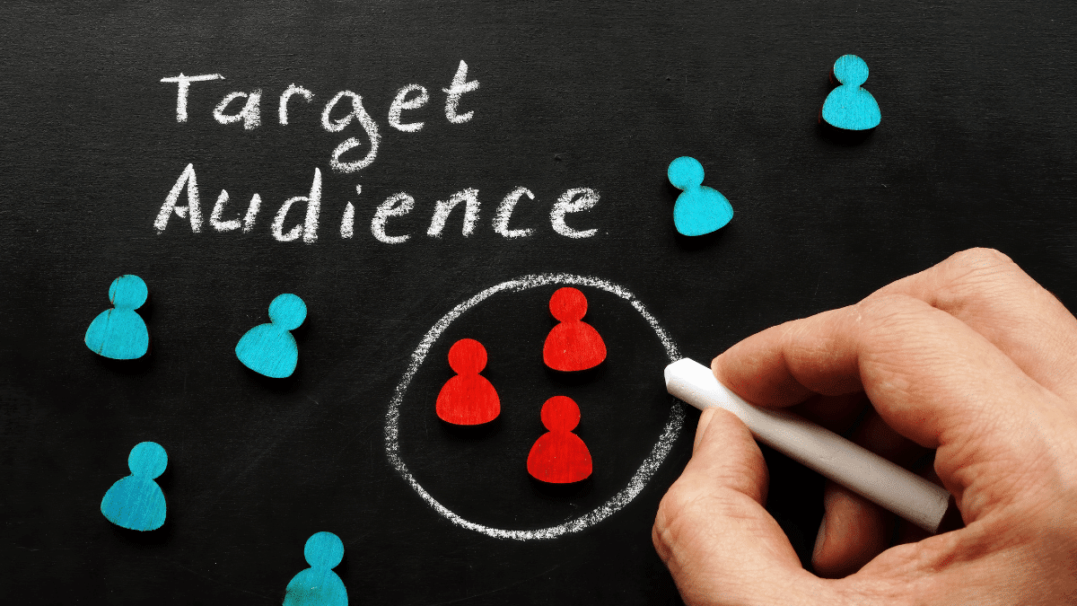 άνδρας κυκλώνει με κιμωλία το target audience σε γραφικό με μαύρο φόντο